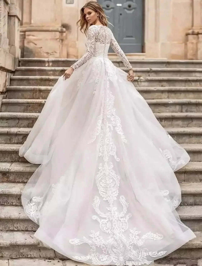 Long Sleeve Wedding Dress With High Waist For Brides in pure white with long lace sleeves and flowing train on stone steps