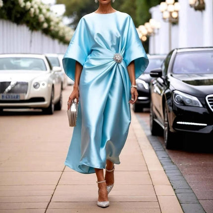 Satin Long High Waist Dress With Pearl Flower Accent in light blue satin, batwing sleeves, draped waist and pearl flower brooch, styled with heels and clutch