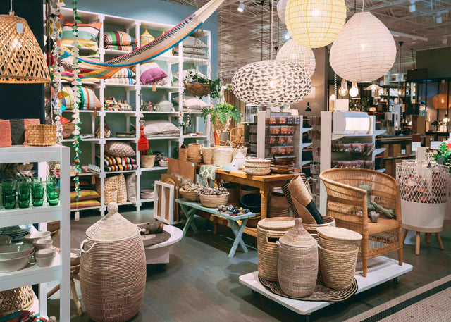 Cozy home decor store display with woven baskets, rattan furniture, hanging paper lanterns, colorful pillows and decorative accessories