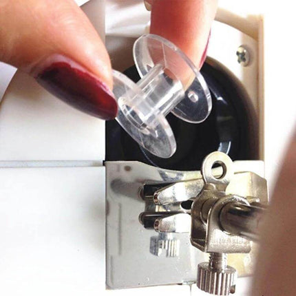 Transparent Bobbin Box for Sewing Machines Holds 25 Bobbins - clear plastic case showing individual bobbin stored near sewing machine