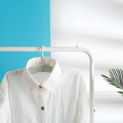 Travel Foldable Clothes Hanger On The Go Anti Skid holding a white shirt on a compact foldable ABS travel hanger for hotel or dorm drying