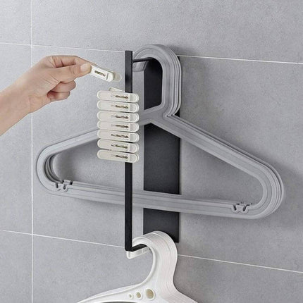 Wall Mounted Clothes Hanger Rack With Double Layer Storage shown mounted on tile wall holding multiple plastic hangers and clips