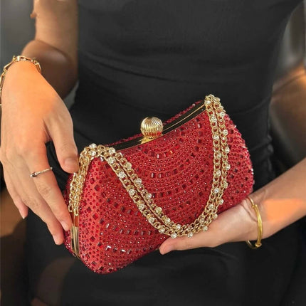 Wine Red Pillow Clutch Bag With Inlaid Diamonds And Chain Strap held by woman, quilted pillow shape with gold-tone chain and decorative rhinestones