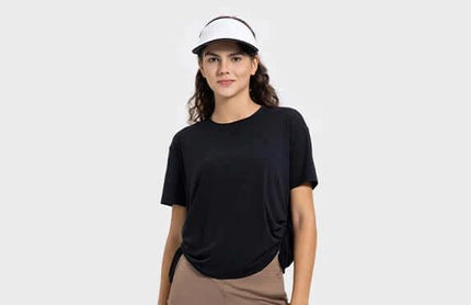 Women's Short Sleeve Side Drawstring Yoga Top Cotton Blend in black on model wearing visor, hip-length pullover with cinched side for adjustable fit