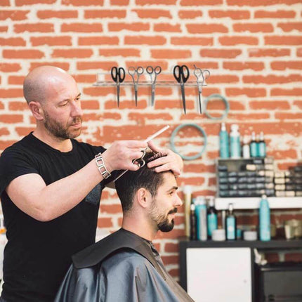 YX162 Acrylic Scissors Wall Mount Bracket 12 Hole Organizer mounted on salon wall above barber cutting client