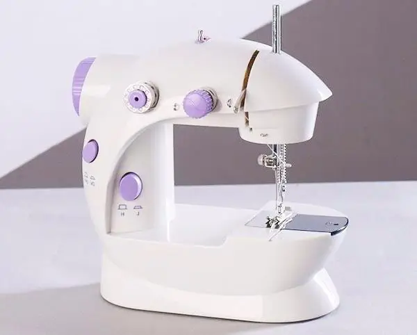 Compact Multifunctional Mini Sewing Machine for Home Projects 1 Compact White Sewing Machine With Purple Knobs And A Silver Needle Plate.