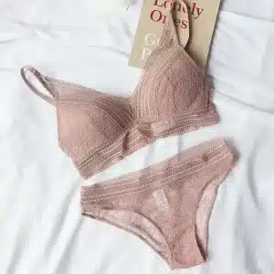 Lace bralette and matching panties in a soft pink color displayed on a white surface.