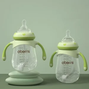 Two Oberni baby bottles with handles in green and transparent design.