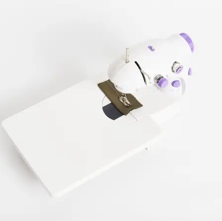 Compact Multifunctional Mini Sewing Machine for Home Projects 4 Compact Sewing Machine In White And Purple Color With A Flat Sewing Surface.