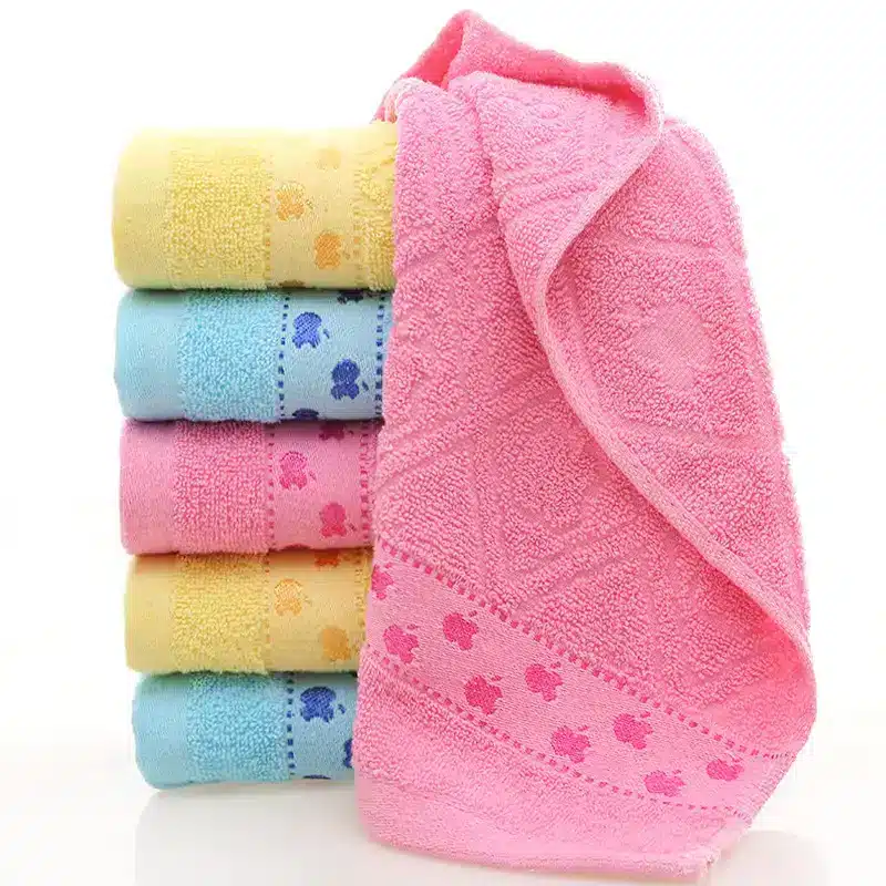 Ultra-Soft Cotton Face Towel for Daily Comfort and Care 3 Stack Of Five Colored Towels In Blue, Yellow, Pink, And Green With A Pink Towel On Top.