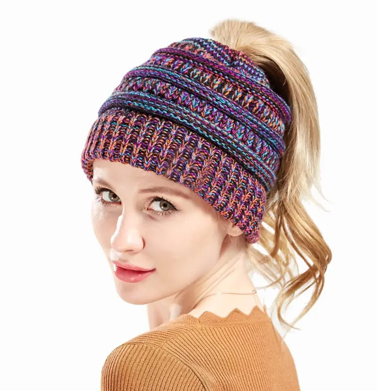 Chic Mixed Color Knitted Ponytail Hat for Ladies 10 A Woman Wearing A Colorful Knitted Beanie With A Ponytail Opening, Showcasing A Blend Of Purple And Blue Hues.