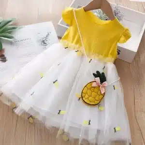 A yellow and white dress featuring a pineapple design and a matching bag.