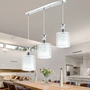Three pendant light fixtures with decorative white shades hanging from a chrome ceiling mount.