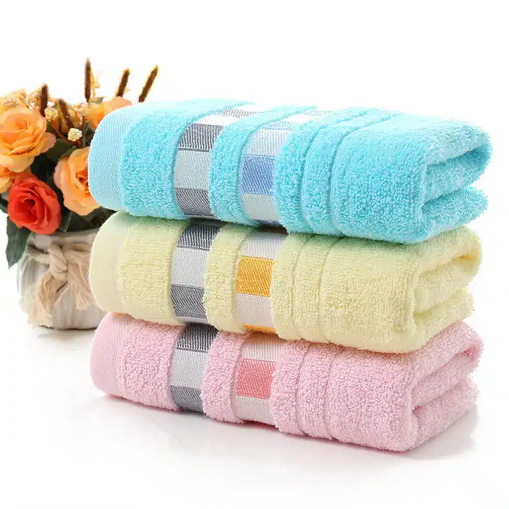Ultra-Soft Cotton Face Towel for Daily Comfort and Care 1 Three Stacked Towels In Blue, Yellow, And Pink With A Striped Pattern.