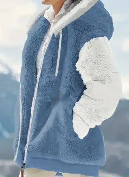 Cozy Women's Winter Jacket for Style and Ultimate Warmth 1 A Blue And White Fleece Jacket With A Hood And Zip Closure Worn By A Person.
