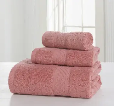 Luxurious Thick Cotton Bath Towel & Robe Set for Spa-Like Comfort 7 Three Stacked Pink Towels Of Varying Sizes On A Flat Surface With A Light Background.