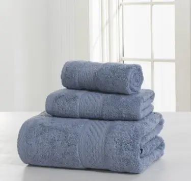 Luxurious Thick Cotton Bath Towel & Robe Set for Spa-Like Comfort 8 Three Blue Bath Towels Stacked On A Flat Surface With A Textured Pattern.