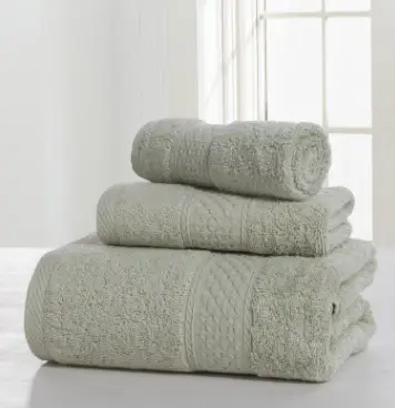 Luxurious Thick Cotton Bath Towel & Robe Set for Spa-Like Comfort 10 Three Soft Green Towels Stacked In A Neat Arrangement, Including A Bath Towel, Hand Towel, And Washcloth.