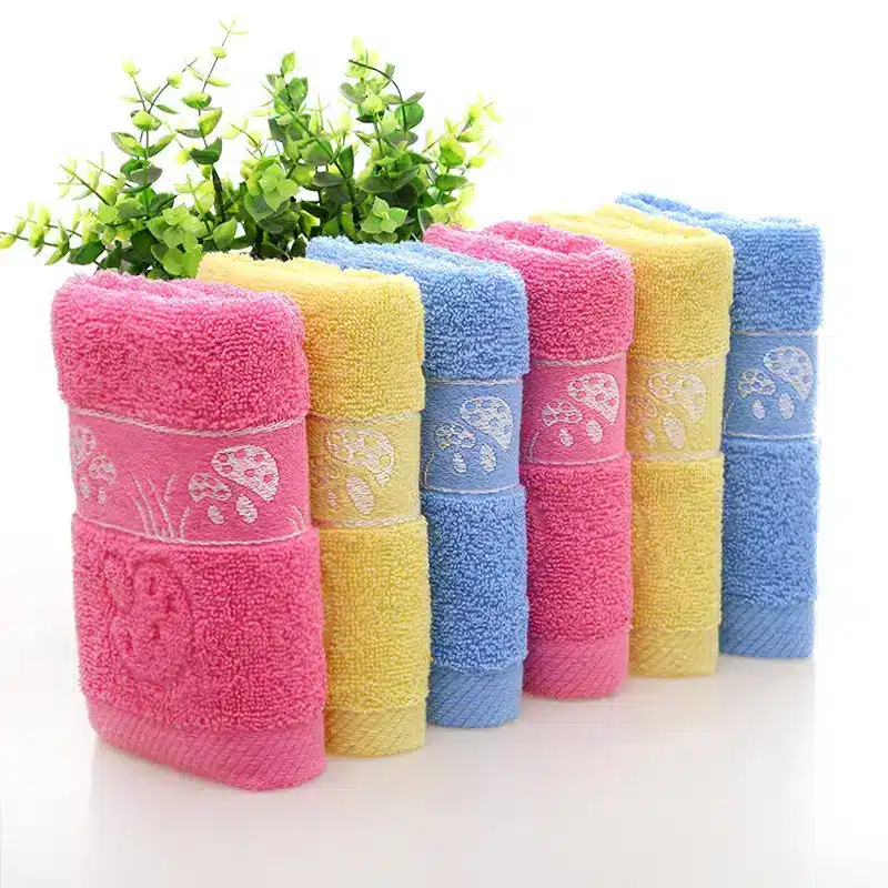 Ultra-Soft Cotton Face Towel for Daily Comfort and Care 6 A Stack Of Six Towels In Pink, Yellow, And Blue Colors With Decorative Patterns.