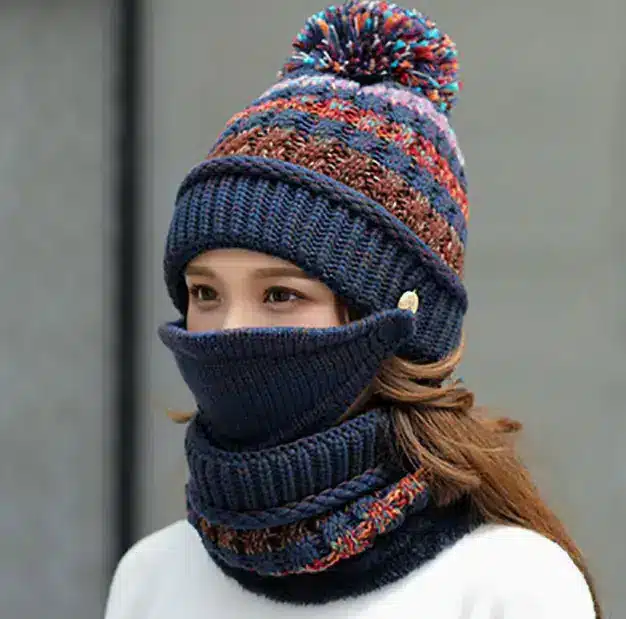 Cozy Korean Winter Knitted Hat for Ultimate Warmth and Style 5 A Woman Wearing A Knitted Winter Hat With A Pom-Pom And A Matching Scarf That Covers Her Face.