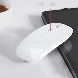 A White Wireless Computer Mouse Positioned Next To A Tablet On A Flat Surface.
