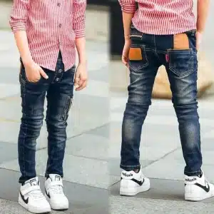 Child wearing blue denim jeans with a striped red shirt and white sneakers, showcasing a casual outfit.