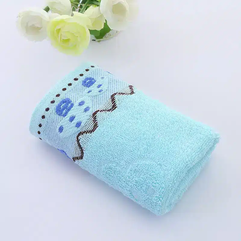 Ultra-Soft Cotton Face Towel for Daily Comfort and Care 10 Folded Blue Towel Featuring A Floral Pattern And Decorative Stitching.