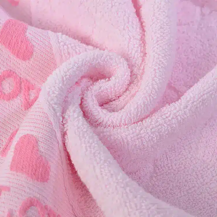 Caring Pure Cotton Face Towel for Gentle Daily Use 4 Close-Up Of A Pink Towel Featuring A Heart Pattern In Soft Fabric Texture.
