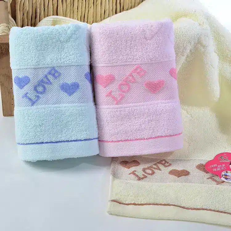 Caring Pure Cotton Face Towel for Gentle Daily Use 6 Two Towels, One Blue And One Pink, Each With The Word 'Love' And Heart Designs.