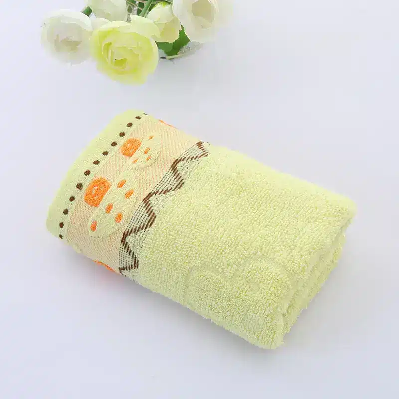 Ultra-Soft Cotton Face Towel for Daily Comfort and Care 4 Folded Yellow Towel Featuring An Orange Floral Design Along The Edge.