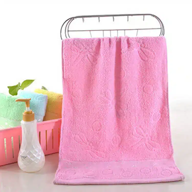 Caring Pure Cotton Face Towel for Gentle Daily Use 8 A Pink Bath Towel Hanging On A Metal Rack With A Decorative Pattern.