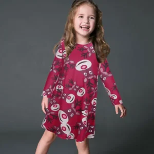 Young girl smiling while wearing a red dress featuring an abstract pattern with circular designs.