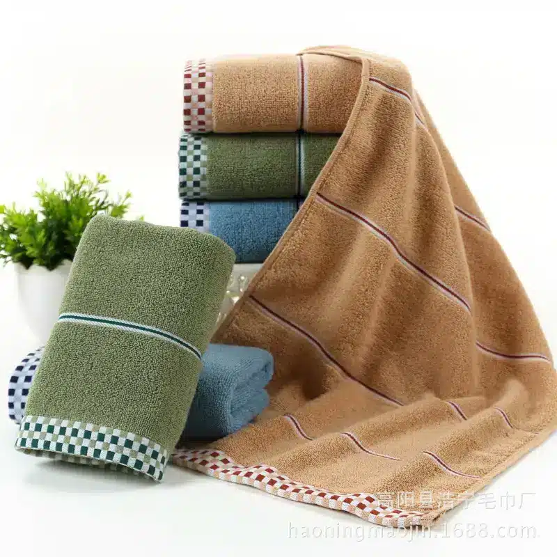 Luxuriously Soft Absorbent Facial Towels for Couples, 2-Pack 9 A Collection Of Colorful Towels In Various Shades Stacked And Displayed With One Towel Draped.