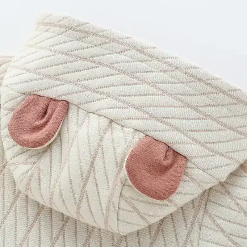 Cozy Long Sleeve Newborn Romper for Tiny Tots 4 Close-Up Of A Textured Fabric Featuring A Geometric Pattern And Pink Accents On The Edges.