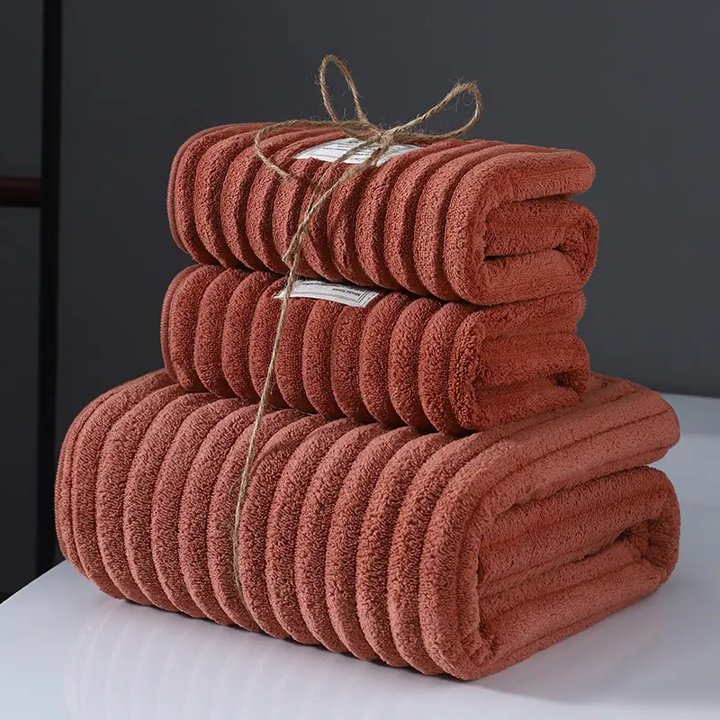 Ultra-Soft Coral Fleece Towels for Quick Absorption & Comfort 1 Three Neatly Folded Towels In A Rust Color, Tied Together With Twine.
