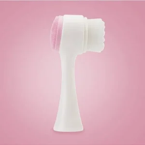 Facial cleansing brush featuring a pink and white design with bristles for skincare.
