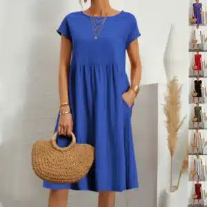A woman wearing a blue short-sleeve dress with a loose fit, holding a woven handbag.