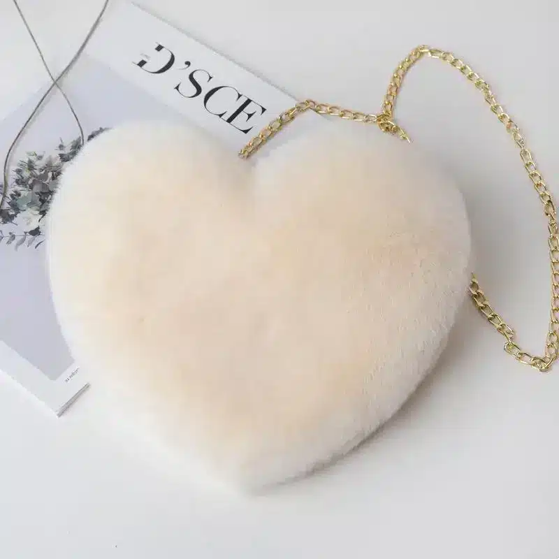 Chic Plush Chain Shoulder Bag for Valentine's Day Delight 4 Cream Heart-Shaped Handbag Made Of Faux Fur With A Gold Chain Strap.