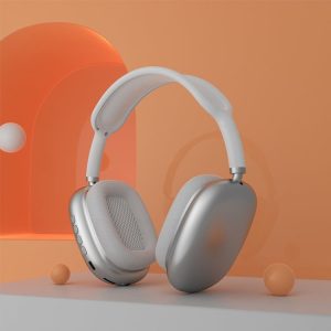 Silver and white over-ear headphones positioned on a light surface with an orange background.