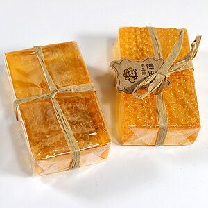 Two rectangular bars of honeycomb soap wrapped in clear plastic with a ribbon and tag.