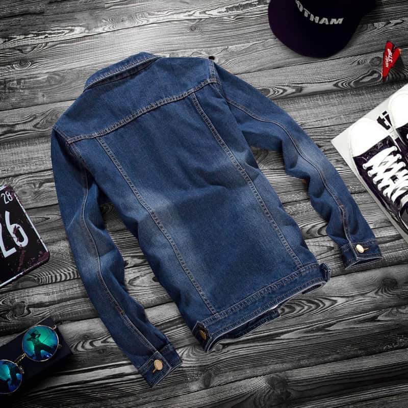 Classic Denim Jacket: Men's Stylish Casual Outerwear with Lapel Detail 5 Back View Of A Blue Denim Jacket Laid Flat On A Wooden Surface.