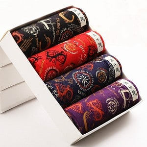Four rolls of decorative fabric in red, black, and purple packaging with various designs.