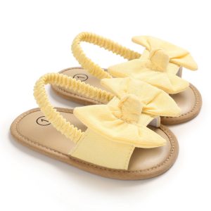 Yellow girls' bow slip-on sandals with elastic straps, perfect for summer comfort and style.