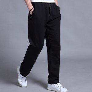 Comfortable men's black jogger pants with elastic waistband and side pockets, ideal for casual wear and sports activities. Perfectly styled with white sneakers for a modern, athletic look.