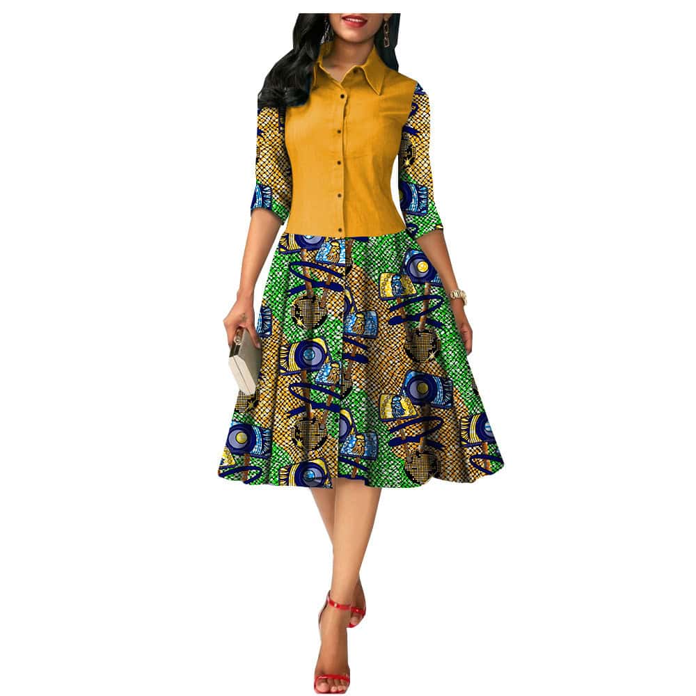 Chic African Print Summer Dress - Ideal for Sunny Days! - Style# 1825054 5 A Woman Wearing A Colorful Dress With A Yellow Top And Patterned Skirt Featuring Blue And Green Designs.