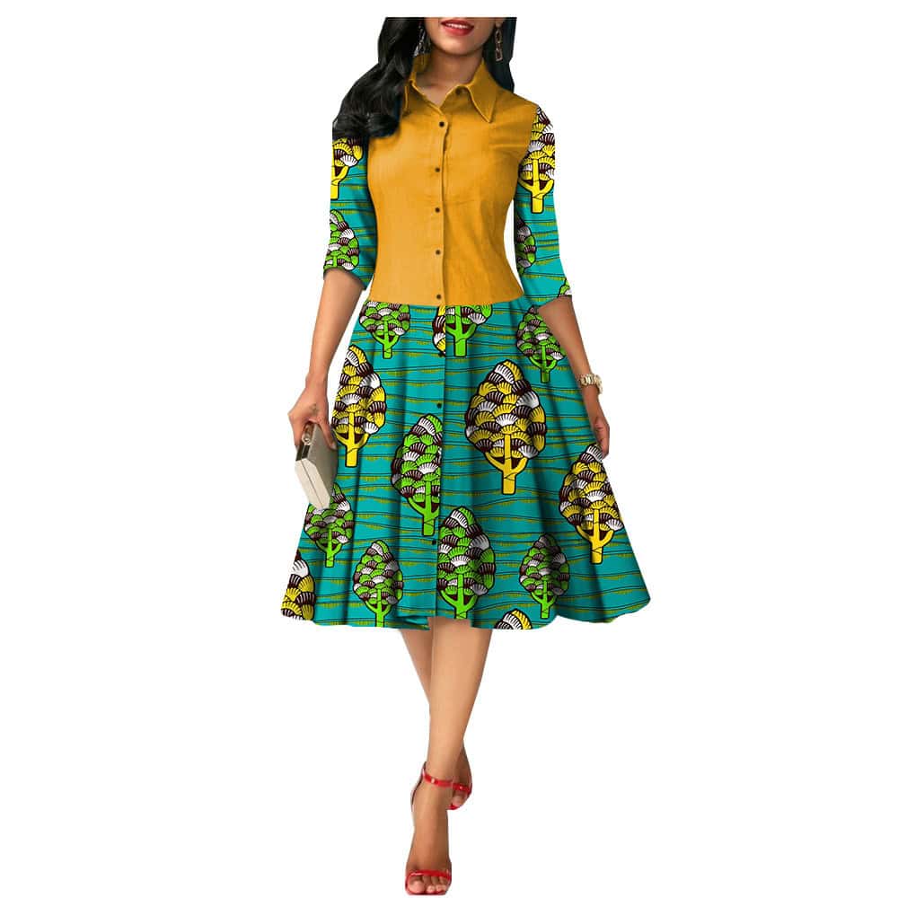 Chic African Print Summer Dress - Ideal for Sunny Days! - Style# 1825054 2 A Woman Wearing A Colorful Dress Featuring A Button-Up Top And A Patterned Skirt With Trees.