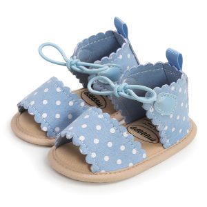 Soft blue baby sandals with polka dots, scalloped edges, and laces, perfect for infants and toddlers. Made from comfortable fabric and cushioned soles for active little feet.