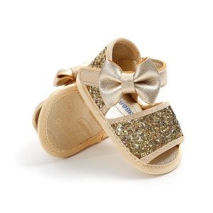 Pair of gold glitter baby sandals featuring a bow on the front strap.