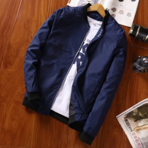 Stylish navy blue bomber jacket displayed on a wooden surface, perfect for casual wear and outdoor activities.