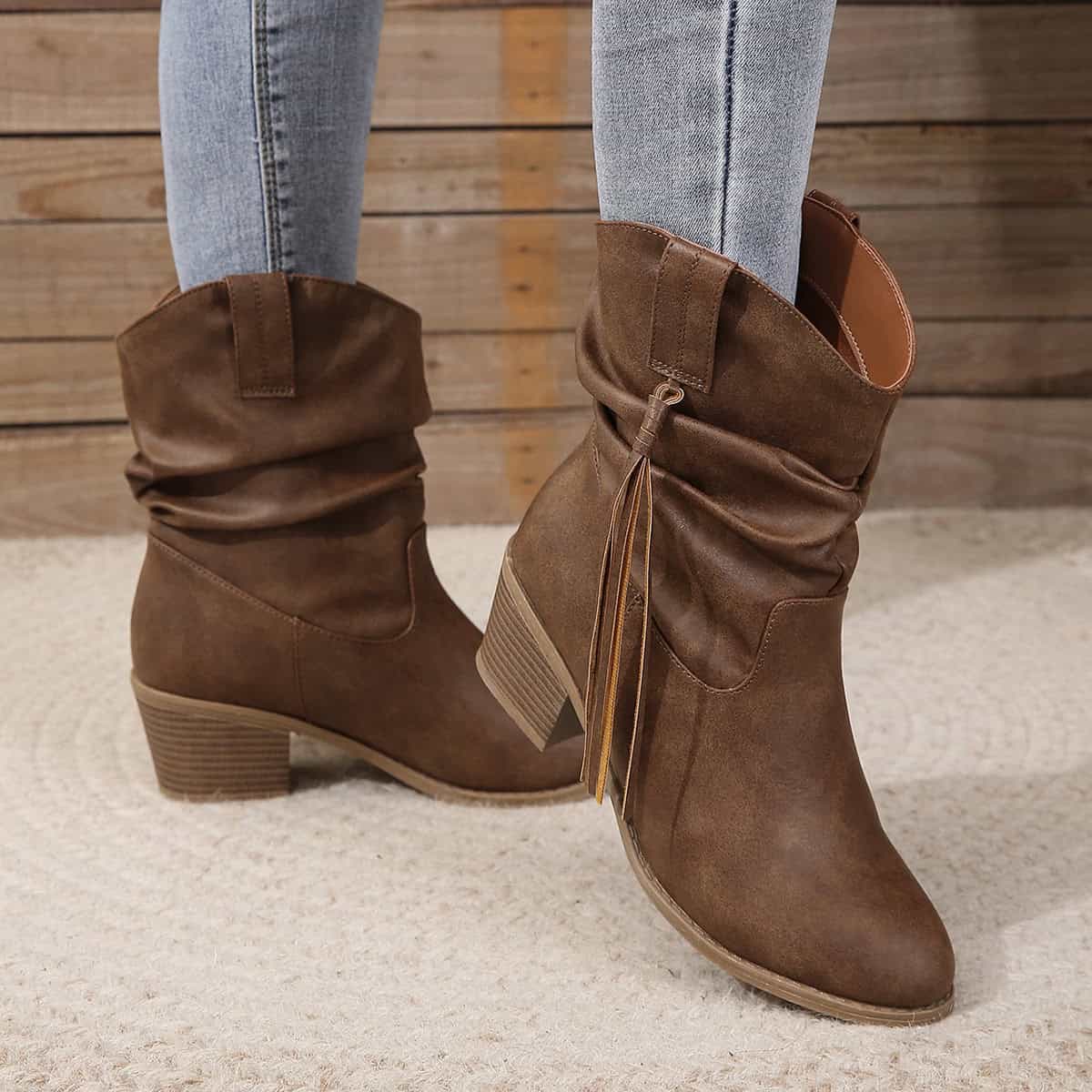 Vintage Western Tassel Mid-Calf Boots - Winter Chic Appeal 4 Brown Leather Ankle Boots With Block Heels, Stylishly Paired With Light Blue Jeans, Ideal For Fall Fashion And Casual Outfits.